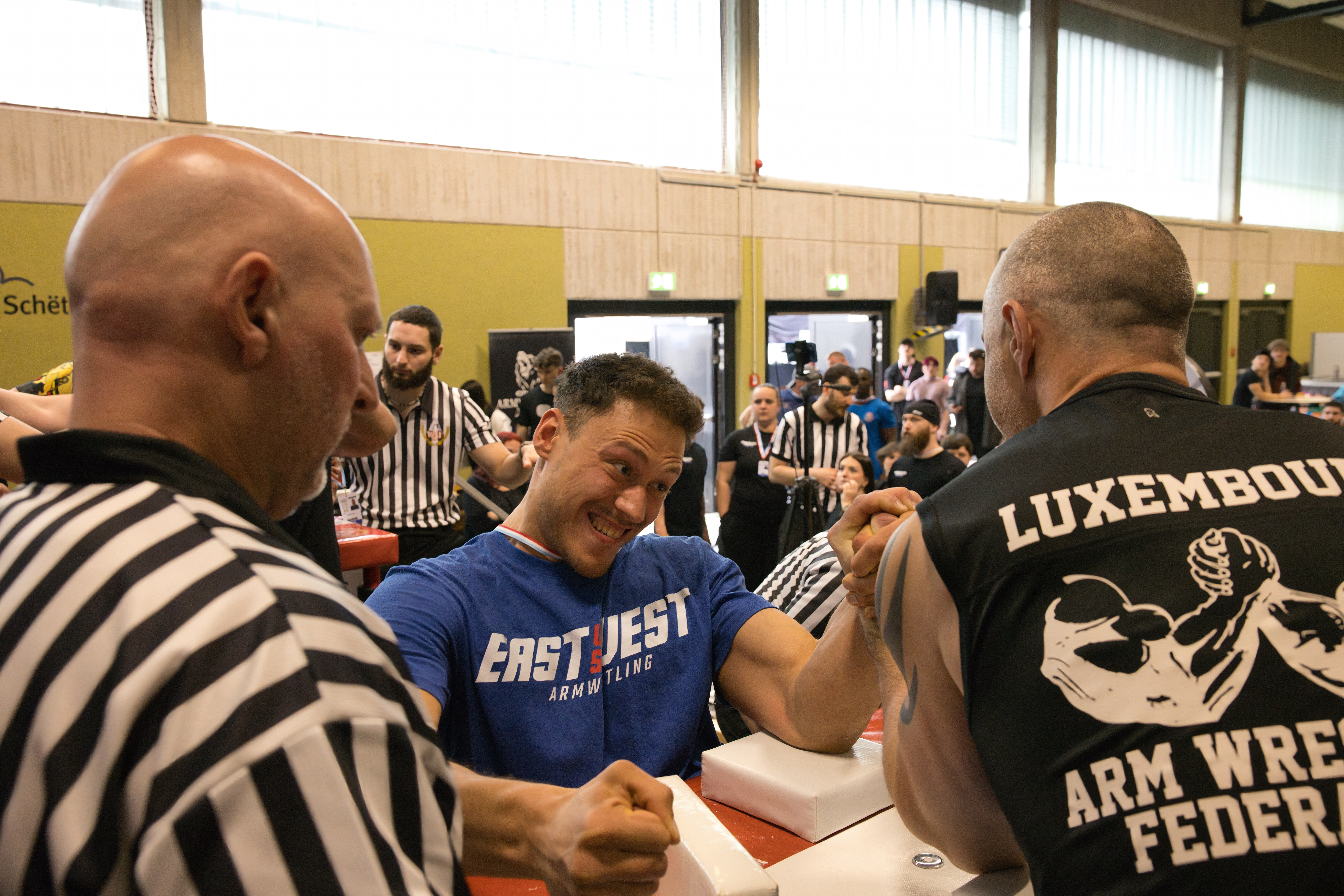 Compétition de bras de fer au Luxembourg avec arbitres officiels, table de match et athlètes de l'Armwrestling Club Strassen et de la fédération luxembourgeoise.